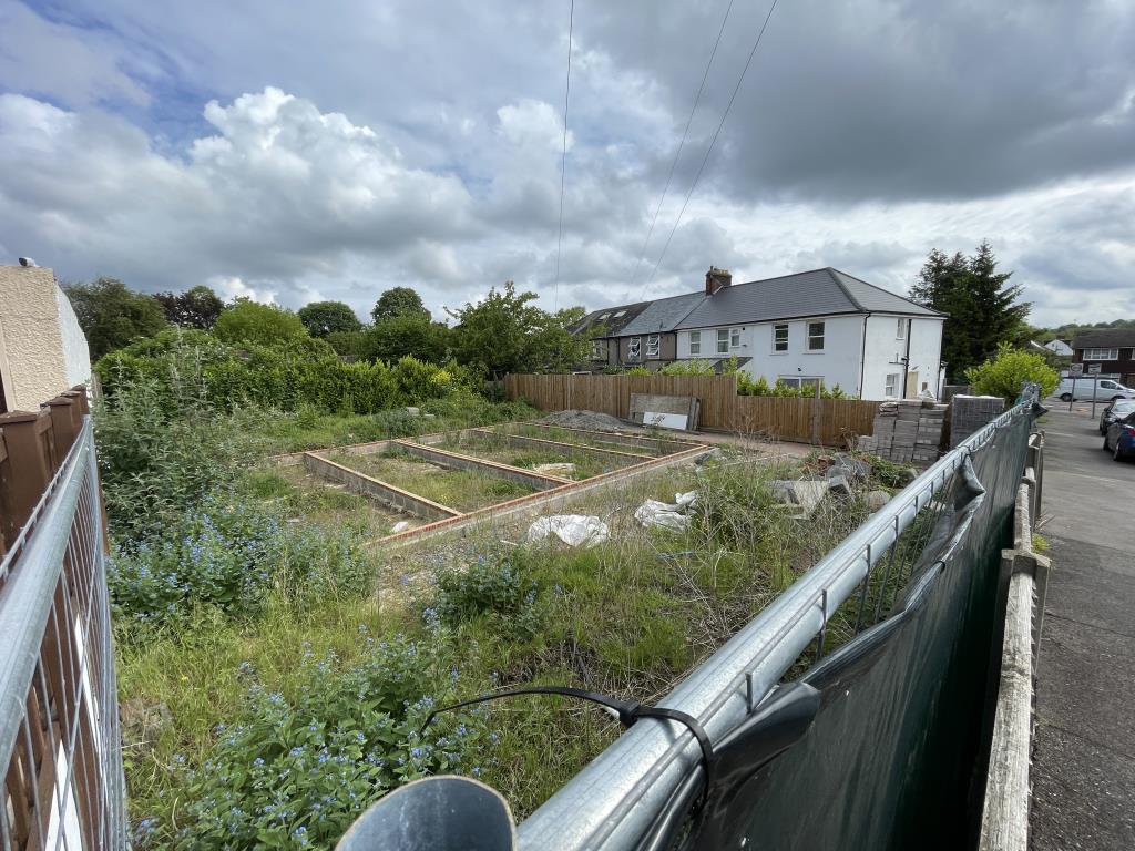 Lot: 117 - PLOT WITH PLANNING FOR TWO SEMI-DETACHED HOUSES - Outside view overlooking front boundary site fence with site of footings and foundations present